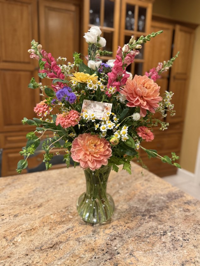 A bouquet of zinnias and snapdragons in a vase