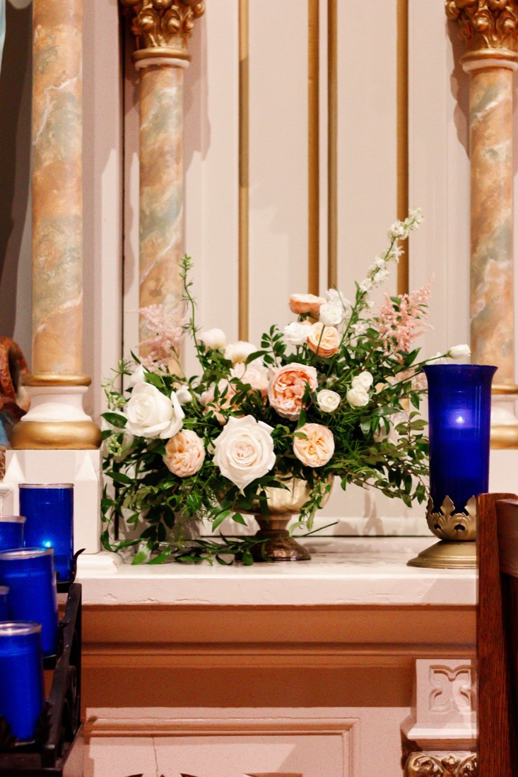 An altar arrangement of white and peach roses