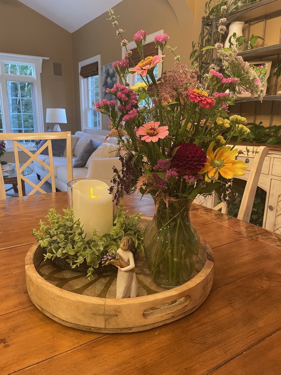 A candle centerpiece with fresh garden flowers